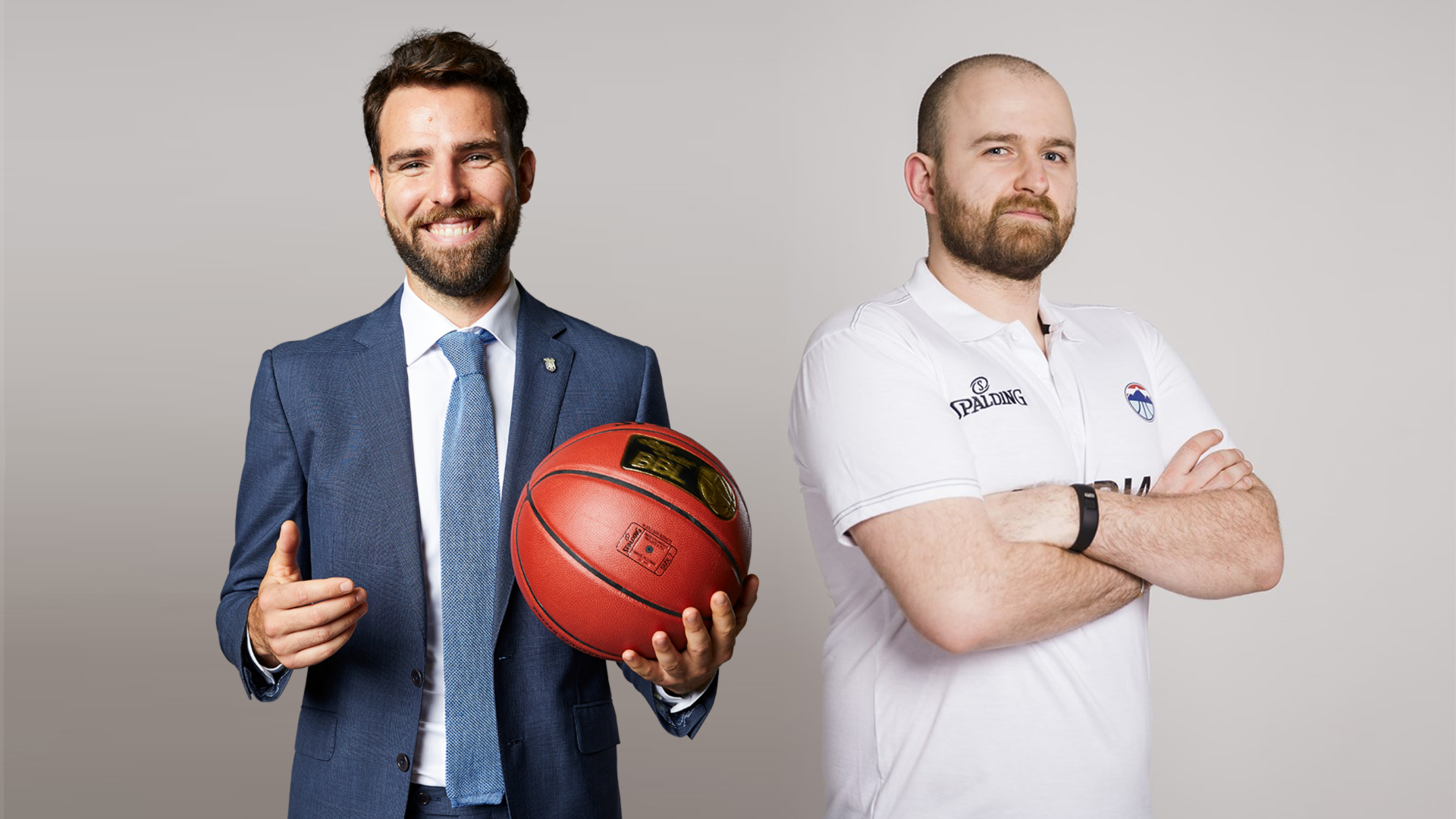 Zwei Männer, einer im blauen Anzug mit Basketball in der Hand, der andere in weißem Sportshirt mit verschränkten Armen, vor neutralem Hintergrund