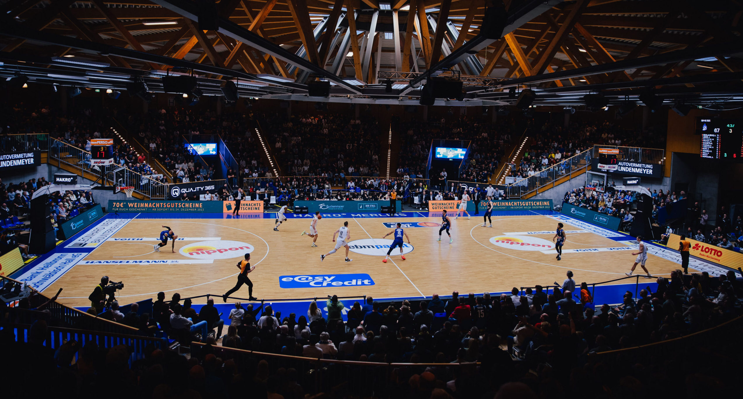 Basketballspiel zwischen HAKRO Merlins und Hamburg Towers in einer Halle mit Zuschauern, Spieler auf dem Spielfeld in Aktion