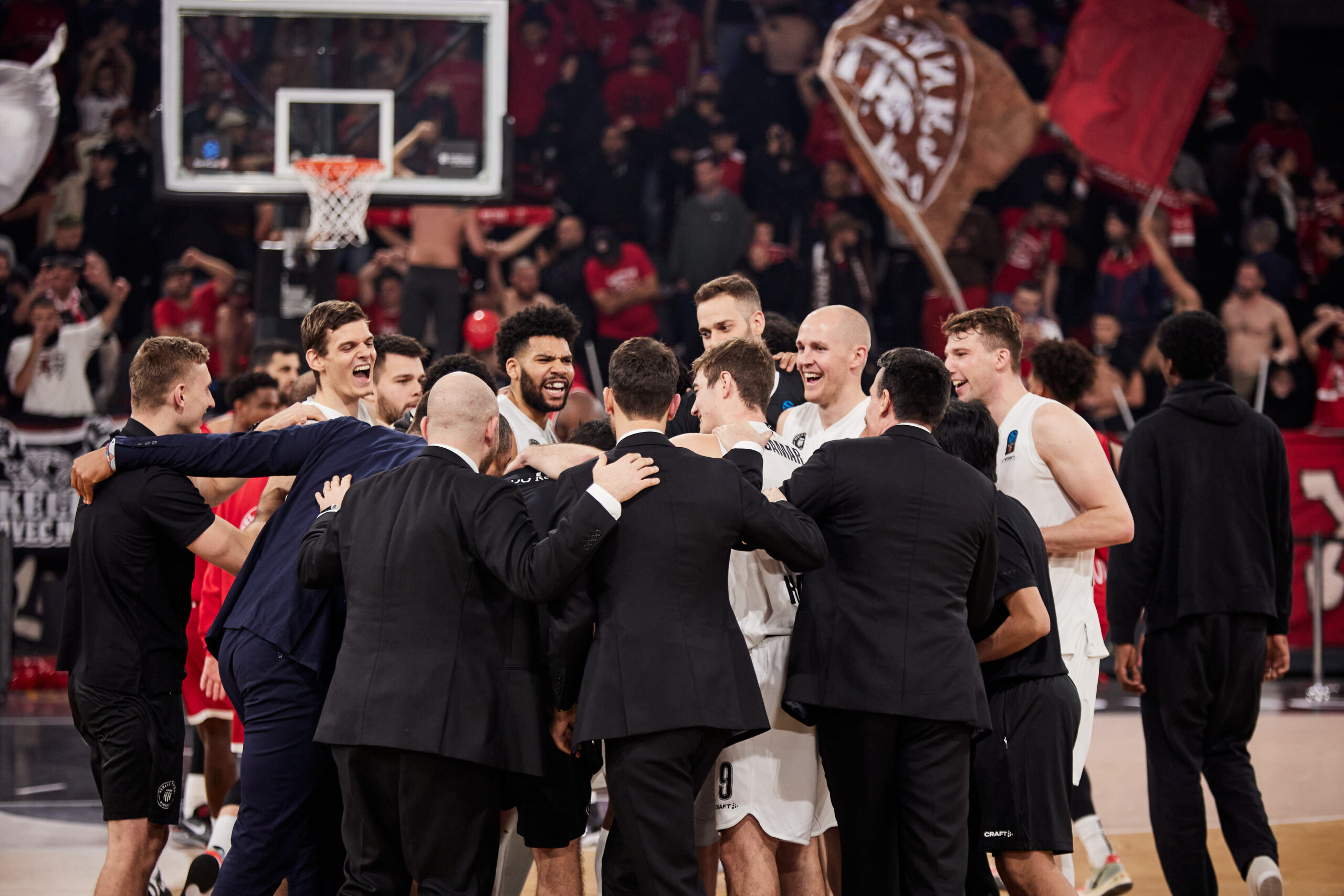 Basketballspieler und Trainer in einem Teamkreis auf dem Spielfeld während eines Spiels zwischen Towers und Tel Aviv