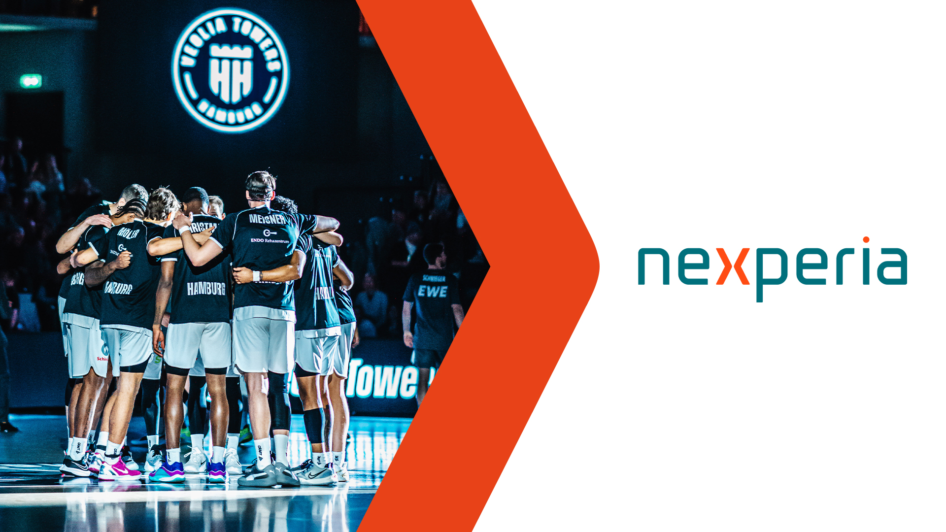 Basketballteam in schwarzer Sportkleidung in einer Gruppenumarmung auf dem Spielfeld neben dem Nexperia-Logo