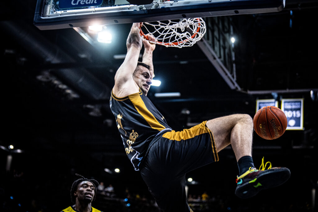Benedikt Turudic hängt im Braunschweiger Trikot nach Dunk am Ring