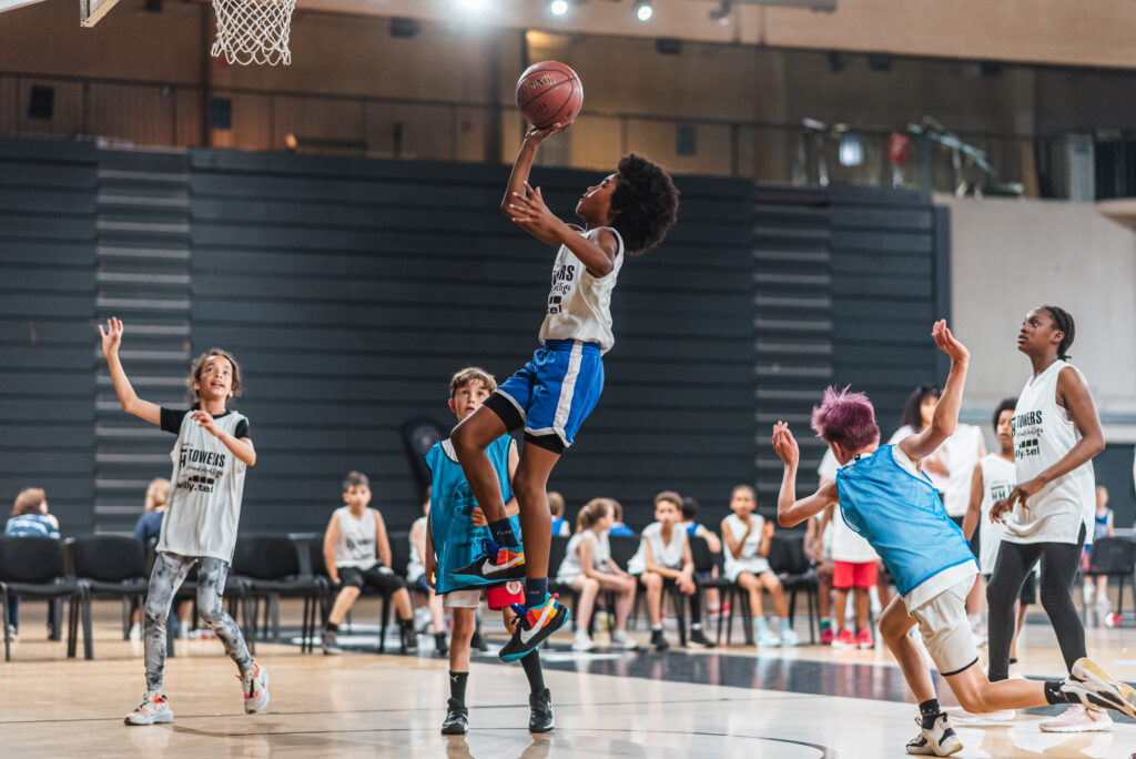 Junge beim Sprung mit Basketball in der Hand bei Grundschulliga