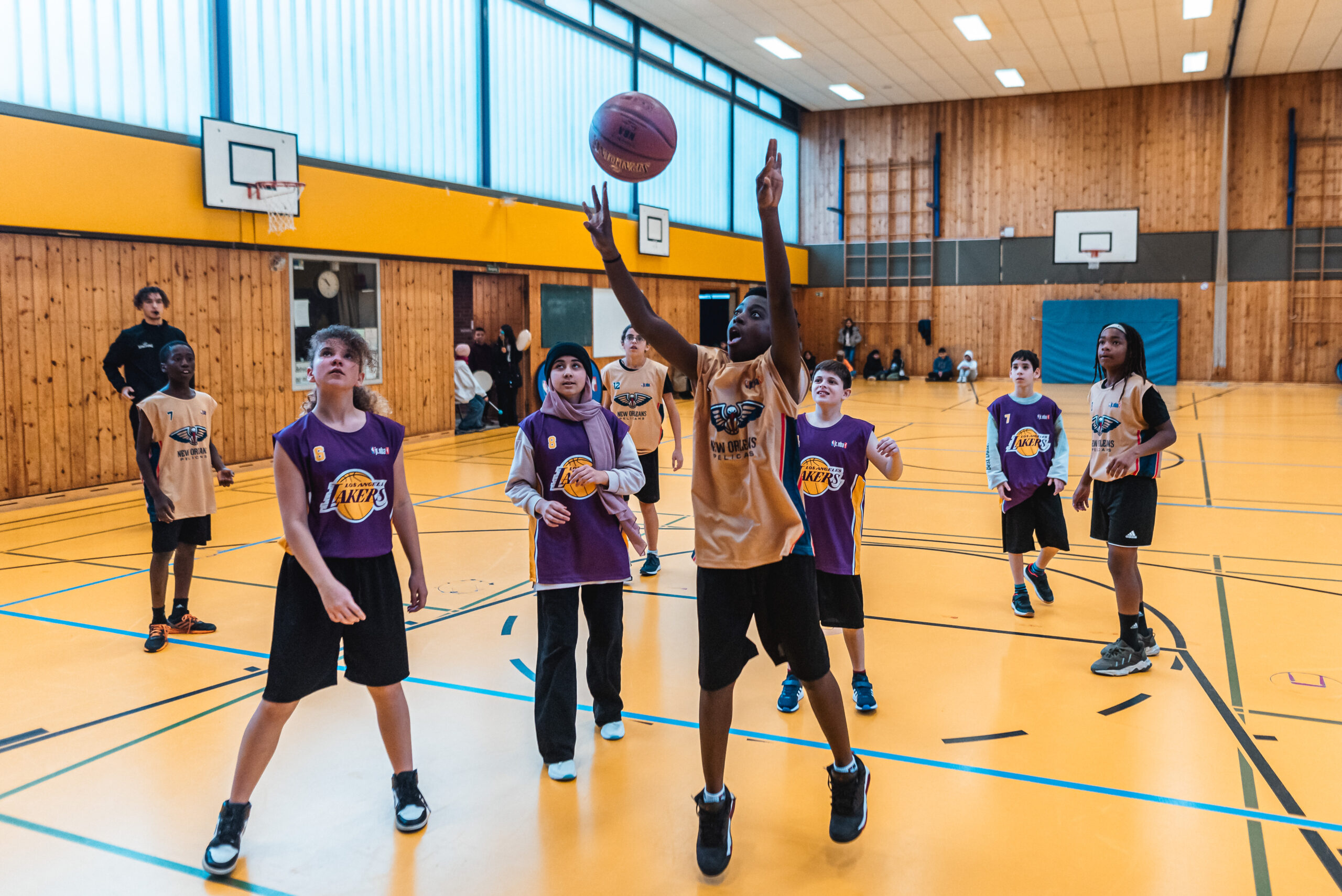 Kinder in Basketballtrikot in einer Sporthalle
