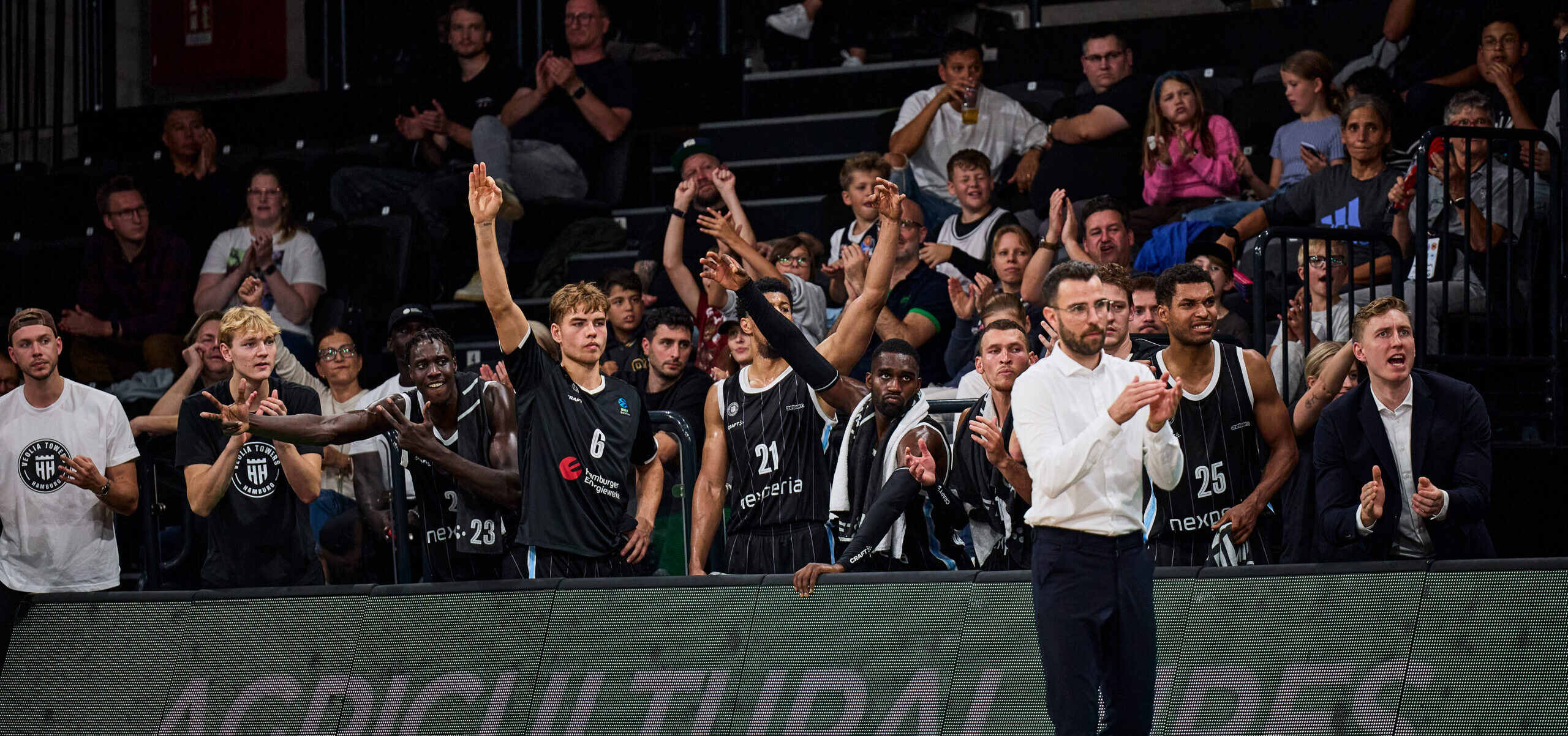 Basketballspieler und Teammitglieder der Towers jubeln auf der Bank während eines Spiels gegen JL Bourg-En-Bresse.