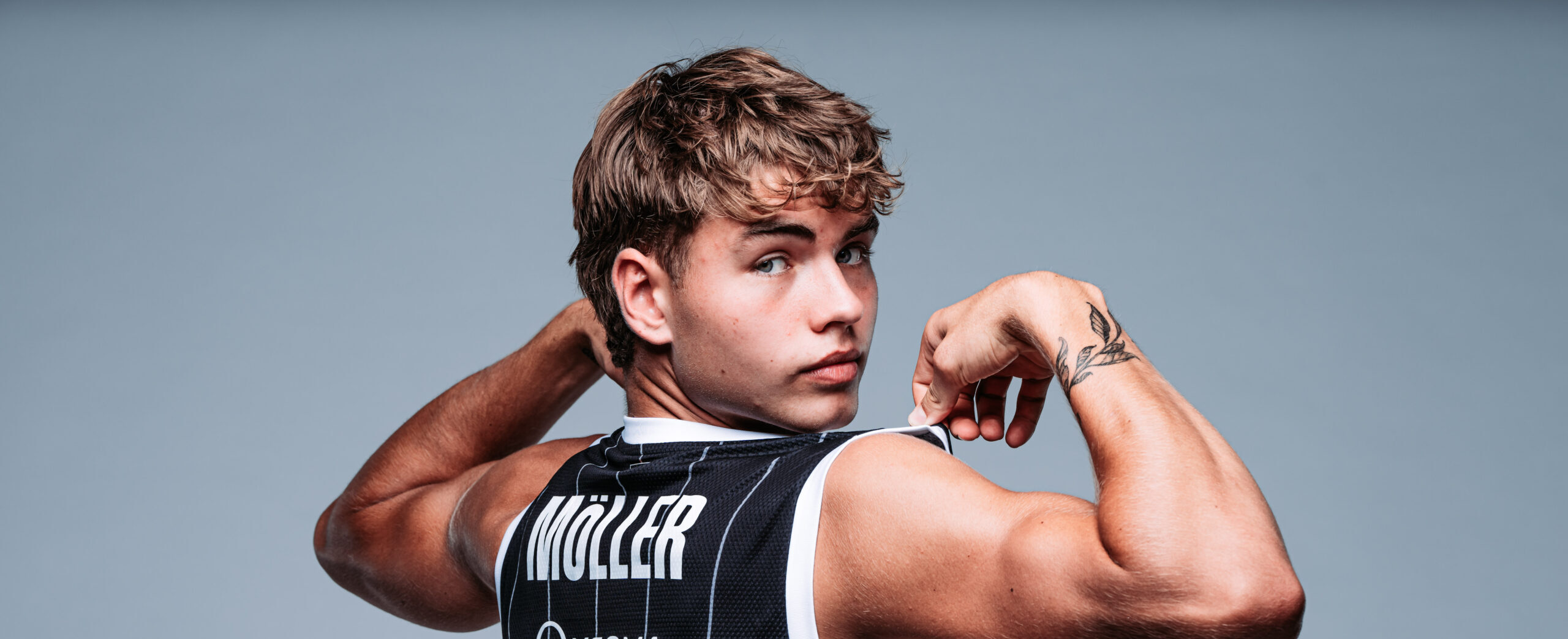Leif Möller in schwarzem Trikot der die Muskeln spielen lässt