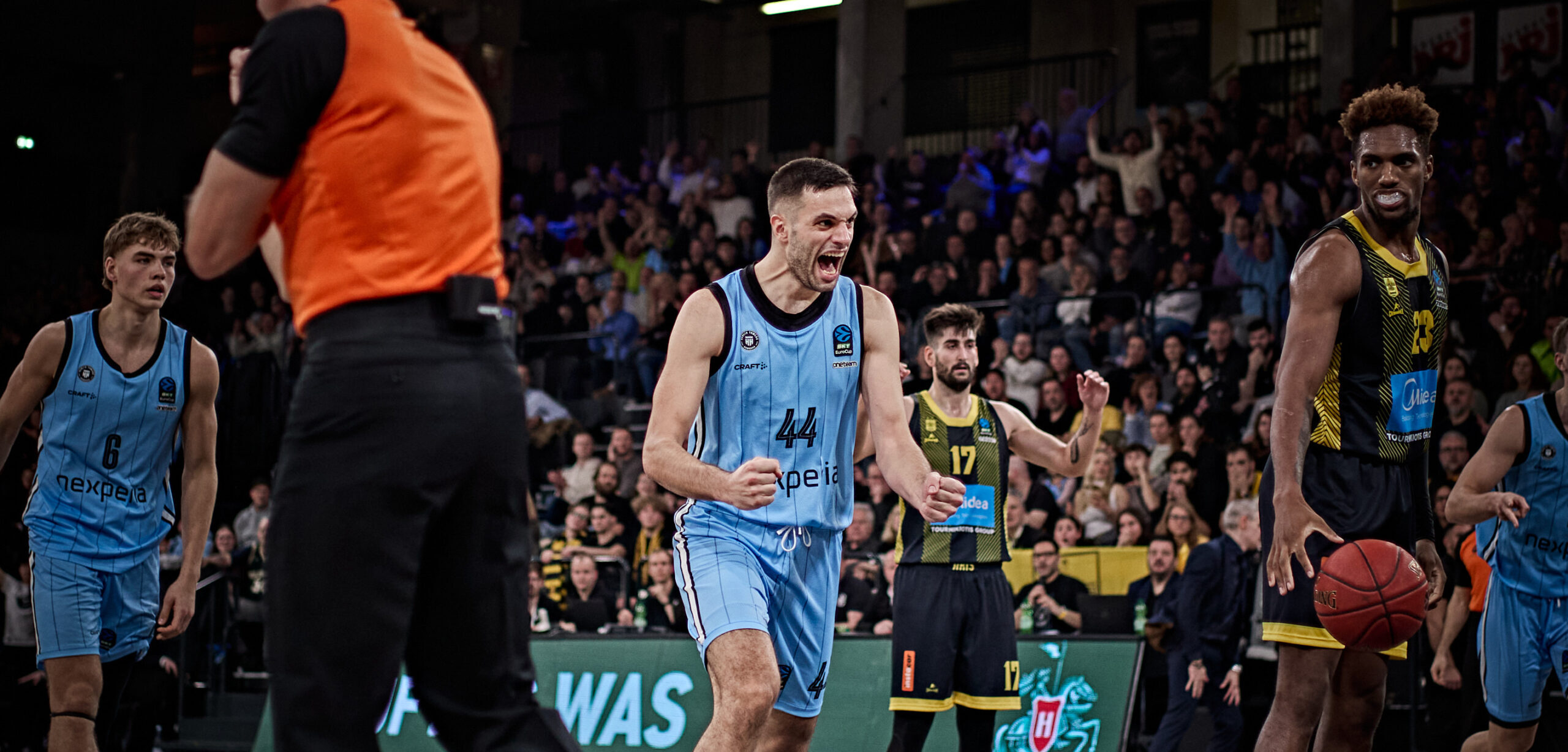 Benedikt Turudic in hellblauem Trikot jubelt emotional auf dem Spielfeld, im Hintergrund Zuschauer
