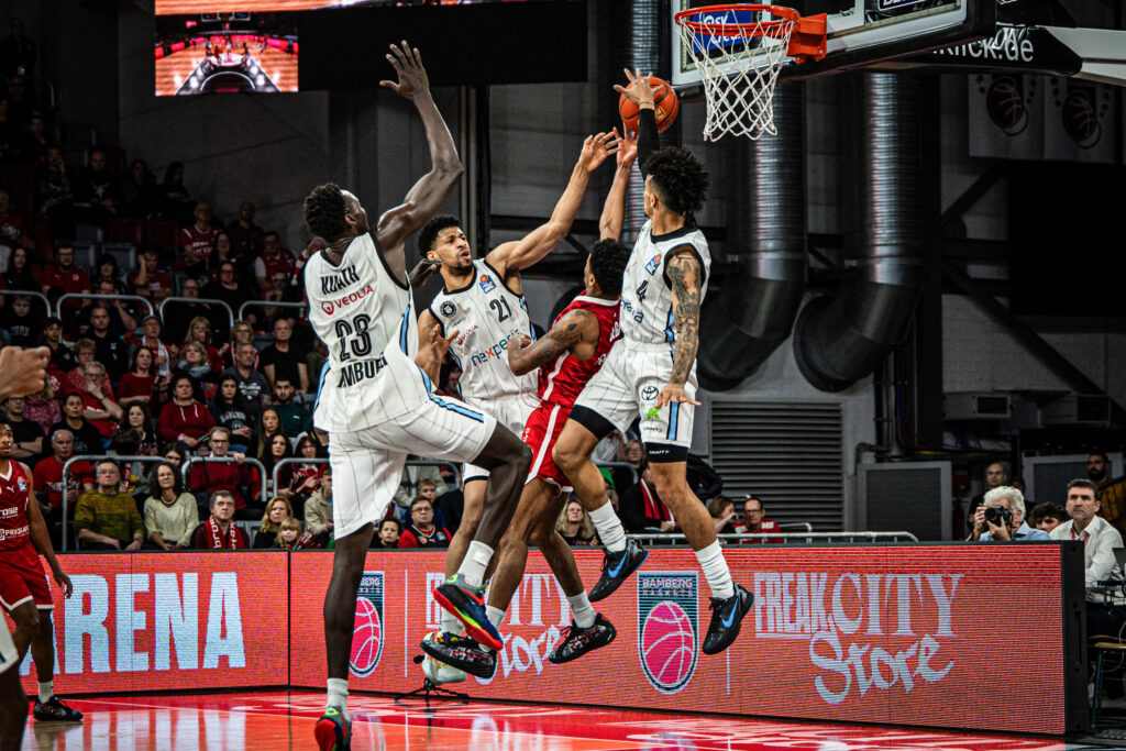 Kur Kuath, Jordan Barnett und Jaizec Lottie hindern Bamberger Gegenspieler am Korberfolg