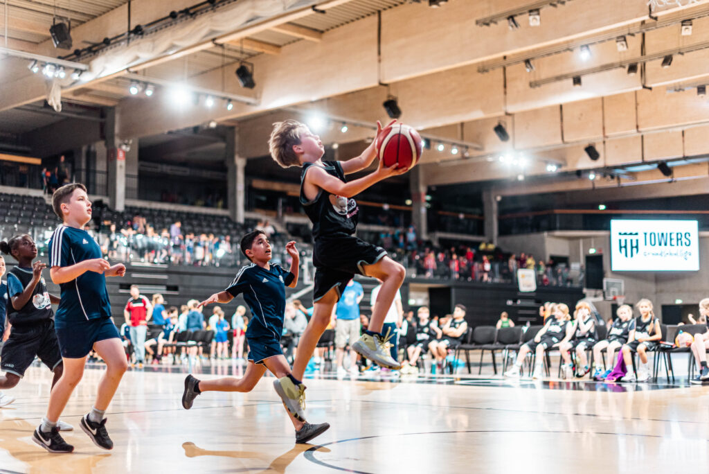 Ein Kind mit Basketball in der Hand beim Korbleger