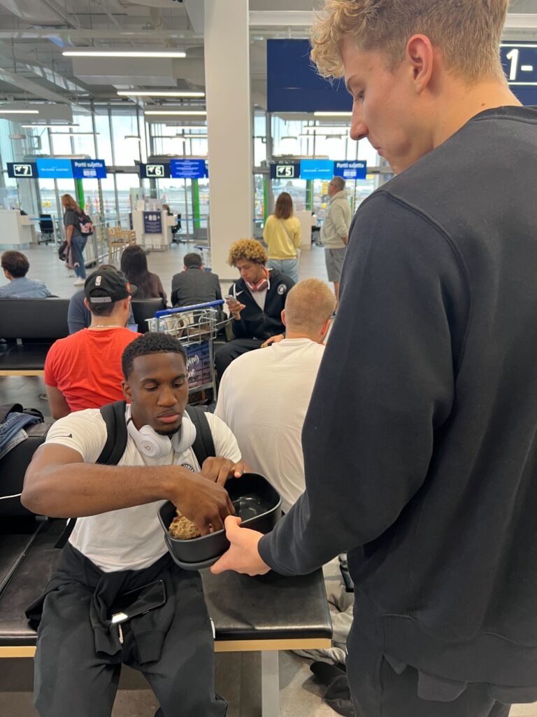 Mann am Flughafen bekommt einen Snack gereicht
