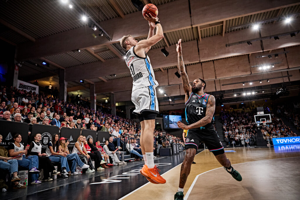 Basketballspieler in weißem Trikot beim Wurf