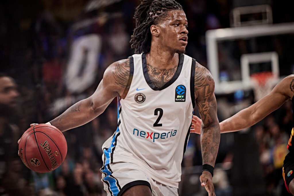 Basketballspieler mit weißem Trikot und Ball in der Hand