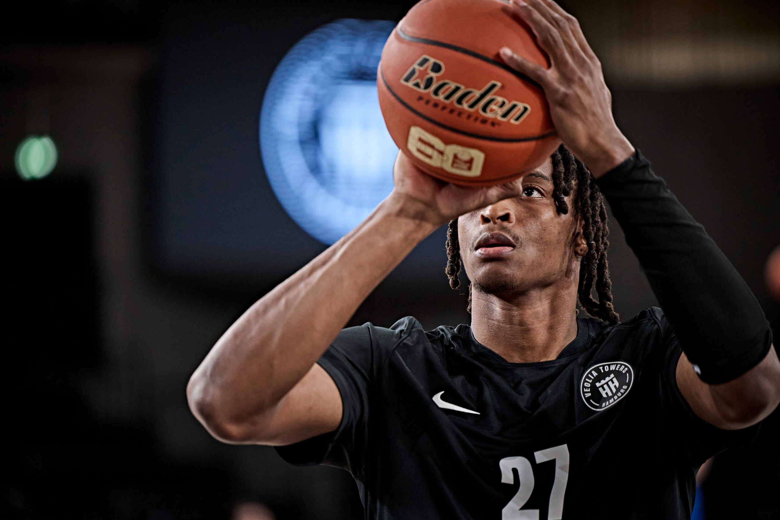 Basketballspieler mit Trikotnummer 27 hält Basketball in Wurfposition