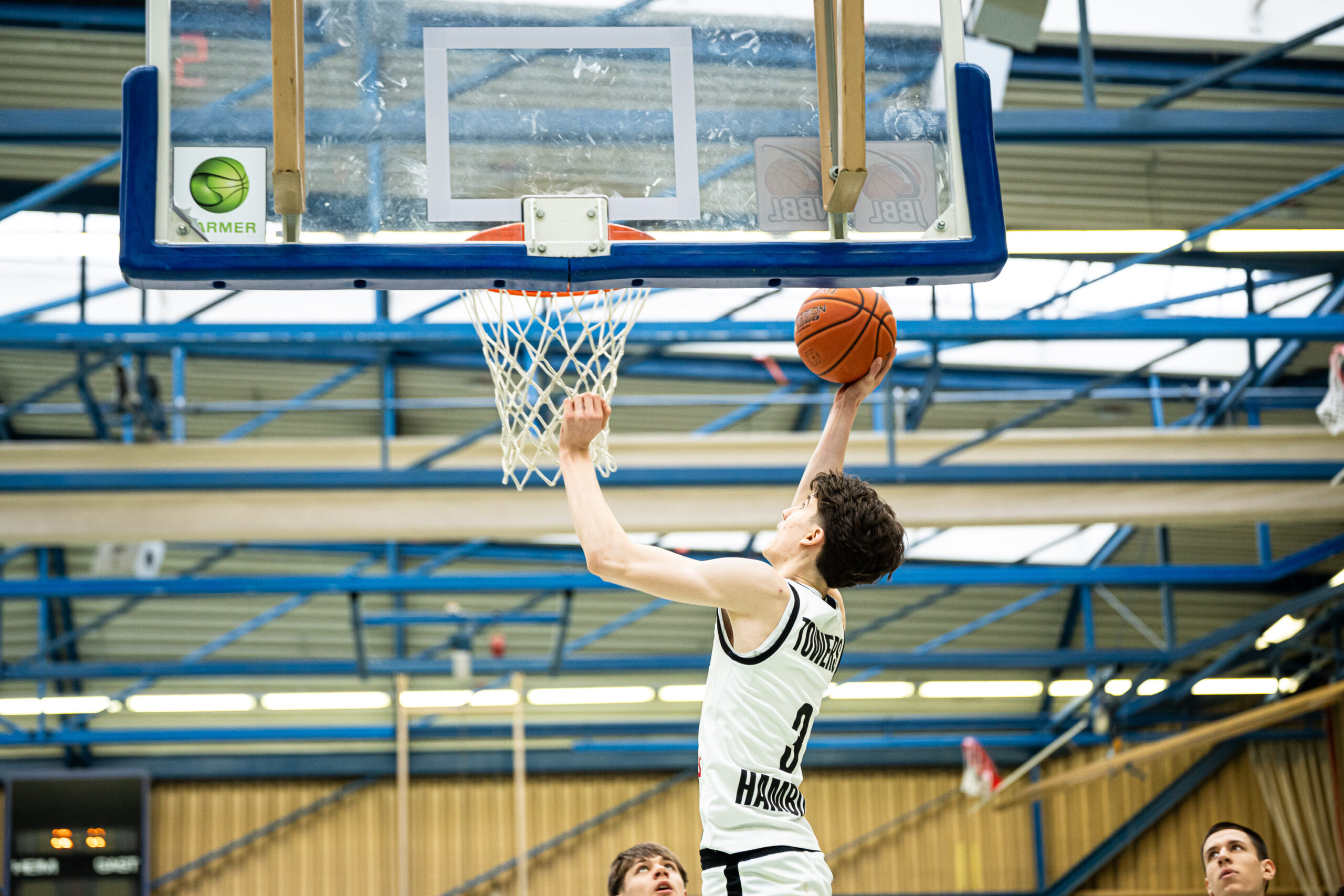 Basketballspieler der Hamburg Towers springt zum Korb für einen Korbleger im Hallenstadion